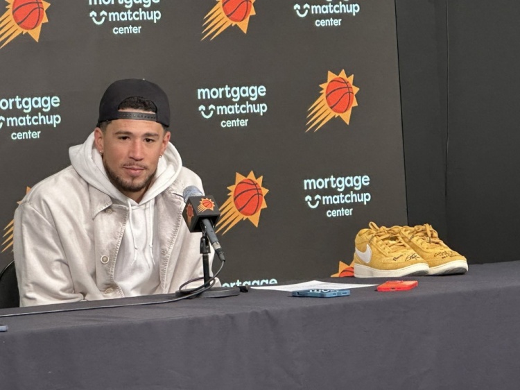 布克赛后拿着库里亲穿的Book1出席采访 上有后者的签名